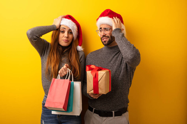 Couple or friends holding gifts and shopping bags worried and overwhelmed - Fotó, kép