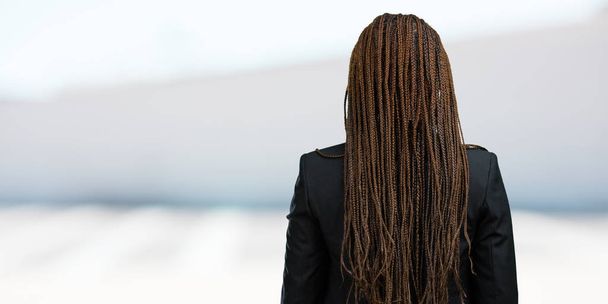 Προσωπογραφία γυναίκας νεαρή μαύρη επιχείρηση δείχνοντας πίσω, ποζάρει και περιμένει, κοιτάζοντας πίσω - Φωτογραφία, εικόνα