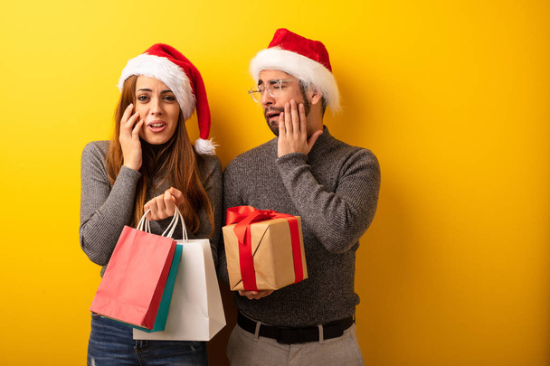 Couple or friends holding gifts and shopping bags desperate and sad - Photo, Image