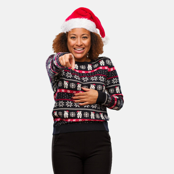 Mujer negra joven en un suéter de Navidad de moda con sueños de impresión de lograr objetivos y propósitos
 - Foto, imagen
