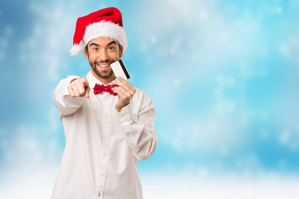 Jeune homme portant un chapeau de Père Noël le jour de Noël
 - Photo, image