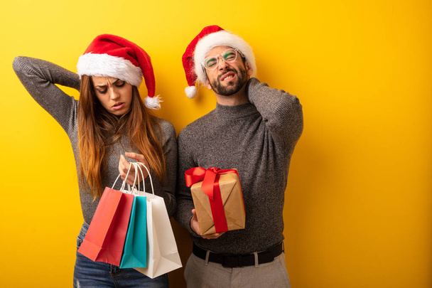 Couple or friends holding gifts and shopping bags suffering neck pain - Photo, Image