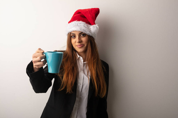 Jeune femme d'affaires portant un chapeau de Père Noël célébrant le jour de Noël
 - Photo, image