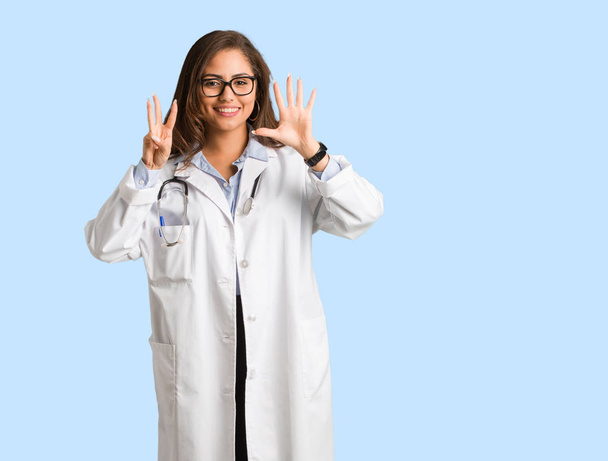 Corpo pieno giovane medico donna mostrando il numero otto
 - Foto, immagini