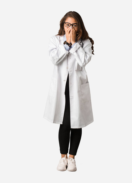 Full body young doctor woman very scared and afraid hidden - Foto, Imagem