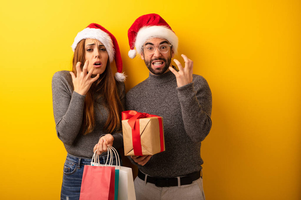 Couple or friends holding gifts and shopping bags very scared and afraid - Photo, Image