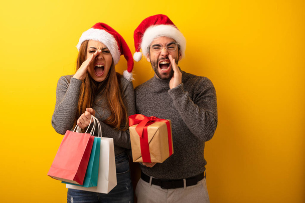 Couple or friends holding gifts and shopping bags shouting something happy to the front - Photo, Image