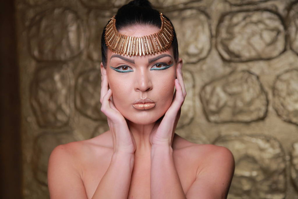 Pretty Tan Brunette Posing. Egypt Style Rich Luxury Woman With Jewellery on Golden Background. - Fotoğraf, Görsel
