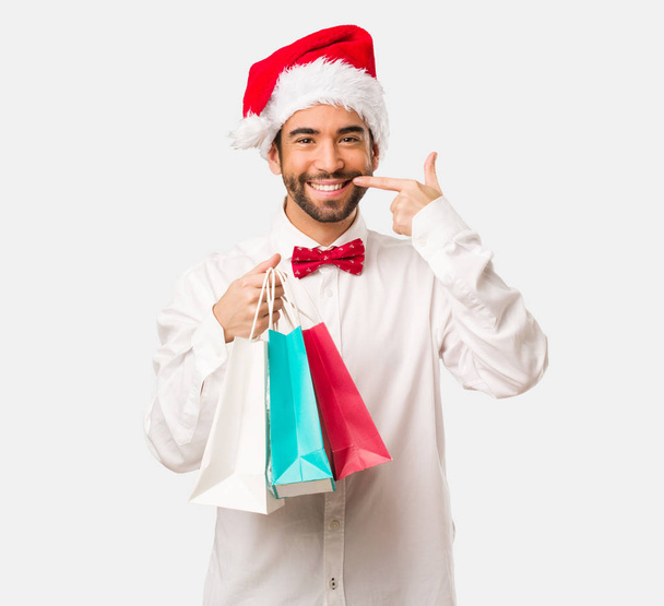Young man wearing a santa claus hat on Christmas day - Фото, изображение