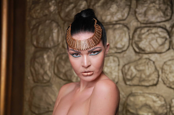 Pretty Tan Brunette Posing. Egypt Style Rich Luxury Woman With Jewellery on Golden Background. - Photo, Image
