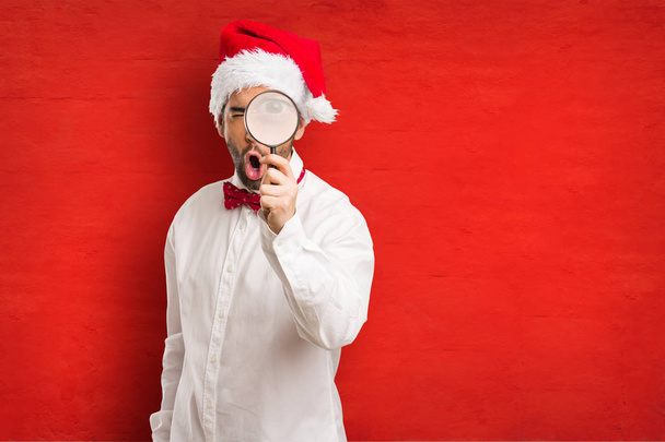 Junger Mann mit Weihnachtsmann-Hut an Heiligabend - Foto, Bild
