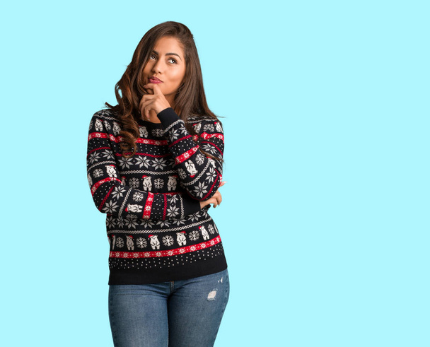 Full body young woman wearing a christmas jersey doubting and confused - Photo, image