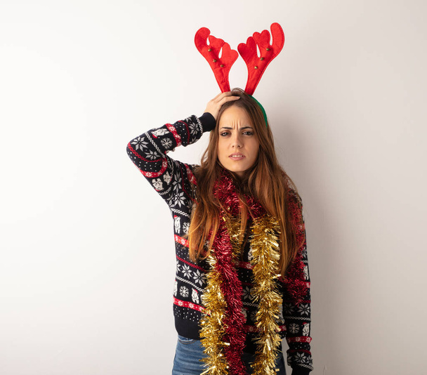 Mladá krásná žena nosí vánoční oblečení únavy a ospalosti - Fotografie, Obrázek