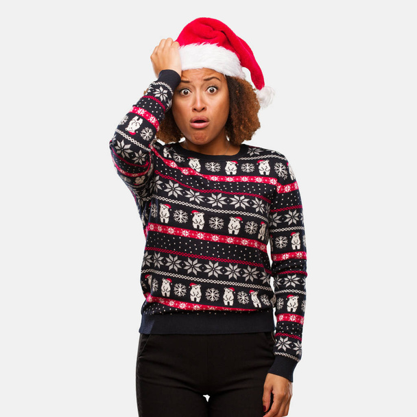 若いは、トレンディなクリスマス セーター印刷心配と圧倒される女性を黒します。 - 写真・画像