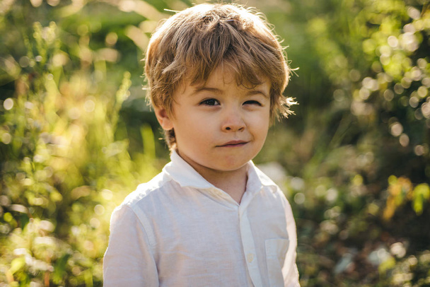 Funny child winking. A kid winking an eye, emoji. Happy cute boy. Beautiful portrait. Expressive facial expressions. Winking and smiling emoticon. Tricky child. Funny idea, prankster - Fotó, kép