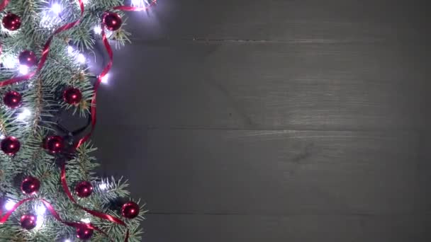 Fond de Noël en bois noir orné de branches de sapin. Pin orné de boules de confettis rouges et de lumières chatoyantes. Vue du dessus, espace pour le message d'accueil. Filmé en résolution 4k
 - Séquence, vidéo