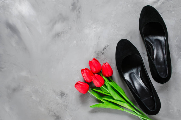 Accessoires pour femmes. Chaussures classiques en daim noir avec talons hauts et tulipes rouges. Style mode. Pose plate
. - Photo, image