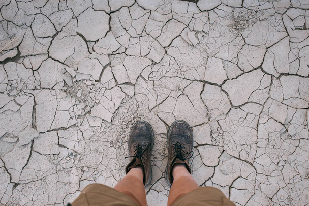 POV of hiking boots on dry ground soil - Fotografie, Obrázek
