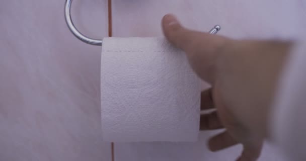 Ręka sięga po ostatni kawałek taśmy papieru toaletowego rollclose-up ręki z ostatni kawałek papieru toaletowego  - Materiał filmowy, wideo