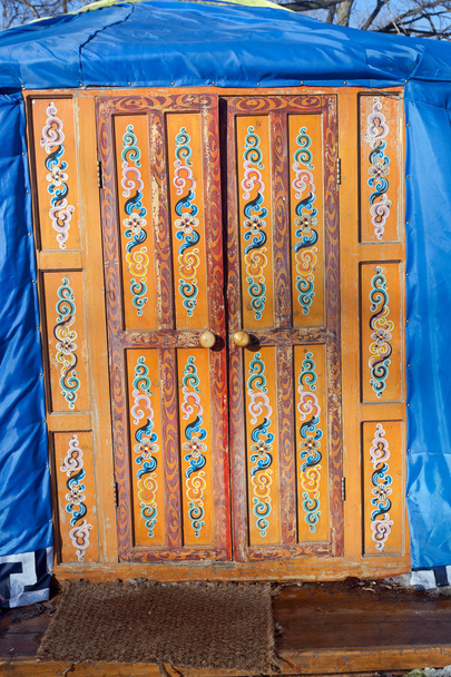 houten ingerichte oranje deur in kazakh yurt - Foto, afbeelding