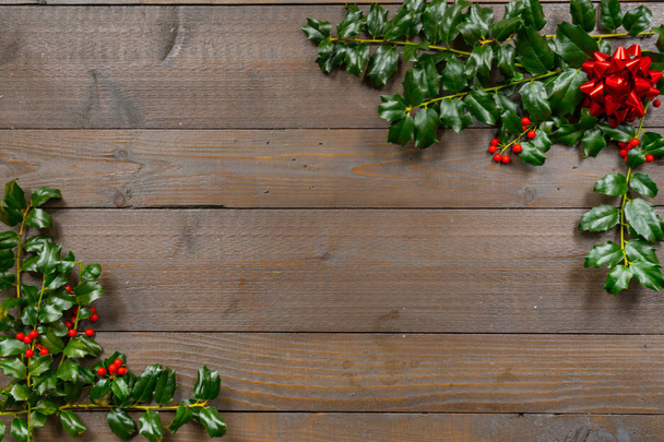 Boże Narodzenie holly z jagodami na tle drewna - Zdjęcie, obraz