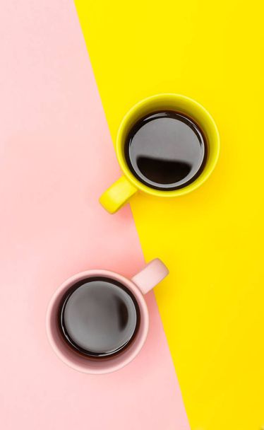 Flat lay vue sur le dessus d'un deux tasses à café avec rose et jaune
. - Photo, image
