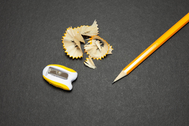 Sharpened pencil and sharpener on black background. - Zdjęcie, obraz