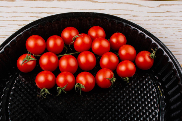 Tomates cerises dans un plateau de cuisson noir exposé
 - Photo, image