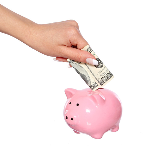 saving money, hand is putting money into piggy bank isolated on white - 写真・画像