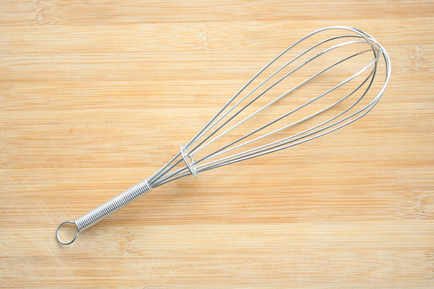 Wire whisk on wooden background - Photo, Image