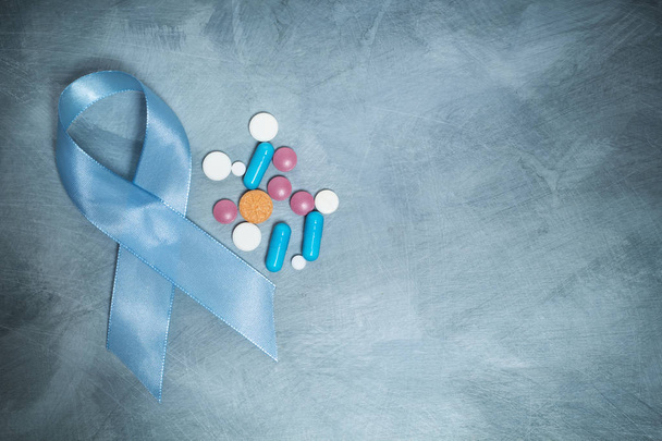 Fita azul e comprimidos, um símbolo de câncer de próstata. Copiar espaço. - Foto, Imagem