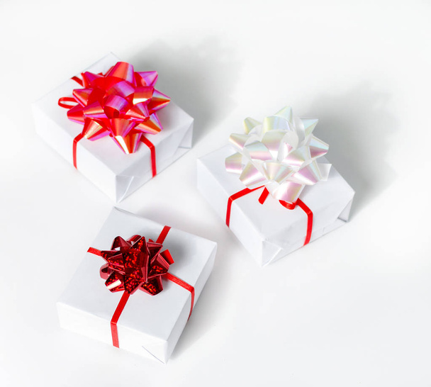 Christmas gift boxes with red ribbons on white table and decoration.Christmas background. - Фото, изображение