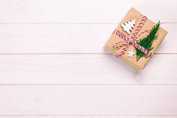 Caja de regalo de Navidad envuelta en papel reciclado, con cinta vintage, vista superior tonificada con espacio para copiar sobre fondo rústico. Concepto de vacaciones
. - Foto, Imagen
