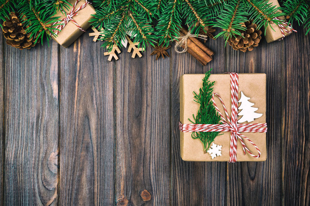 Christmas vintage, toned background with fir tree and gift box on wooden table. Top view with copy space for your design. - Photo, Image