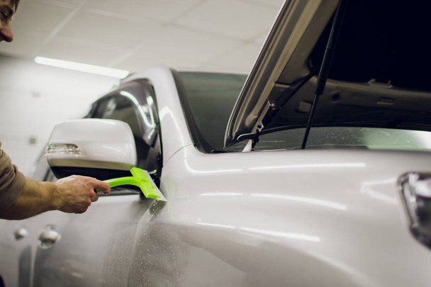 Worker hands installs car paint protection film. - Fotó, kép