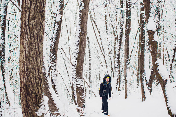 Femme est debout sur la prairie dans la forêt pendant l'hiver
. - Photo, image