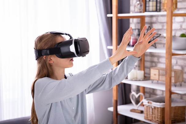 Side View Of A Girl Using Virtual Reality Headset At Home - Foto, Bild