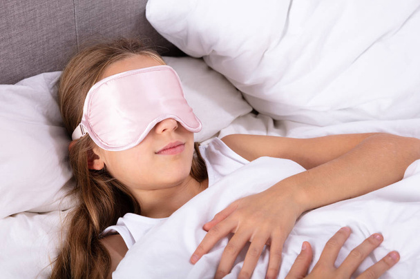Close-up Of A Girl Sleeping With Eye Mask On Bed - 写真・画像