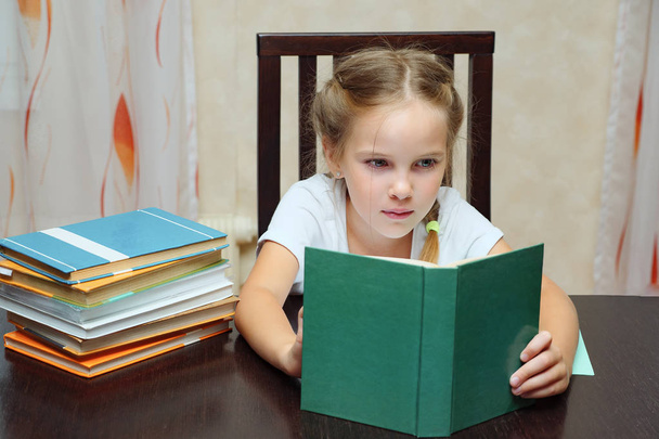 Девочка учится за столом чтения книги
 - Фото, изображение