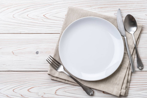 empty plate spoon fork and knife on table - Fotó, kép