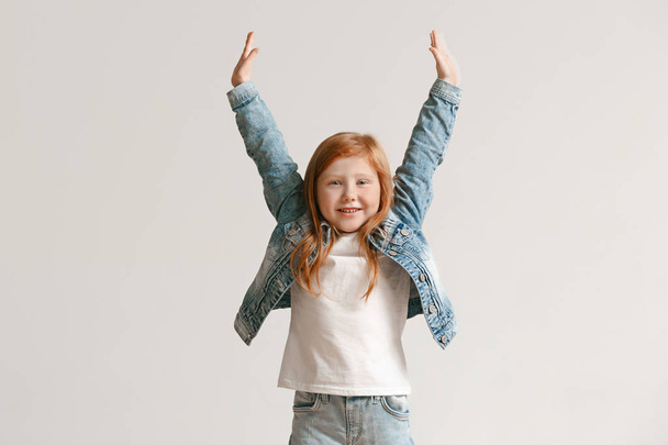 Full length portrait of cute little kid in stylish jeans clothes looking at camera and smiling - Photo, image