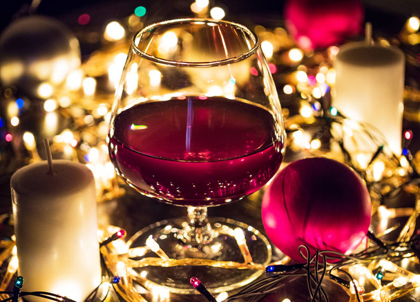 Χριστουγεννιάτικα φωτάκια, μπάλες και κεριά, γυαλί closeup με εφέ θολά φώτα - Φωτογραφία, εικόνα