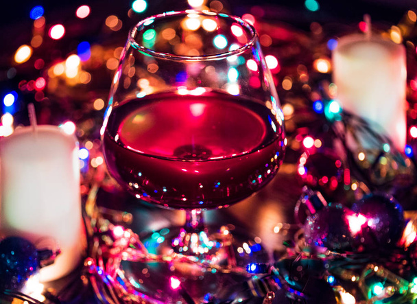 Rubino bere in bicchiere di brandy da vicino. Intorno scintille festone, effetto bokeh
 - Foto, immagini