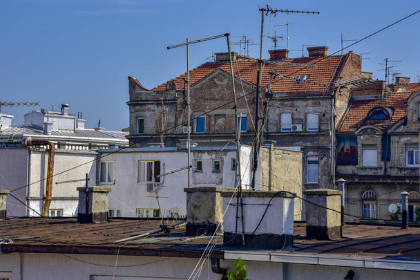 City in Europe the roof of a house window antenna sun in summer blue white Belgrade - Photo, Image