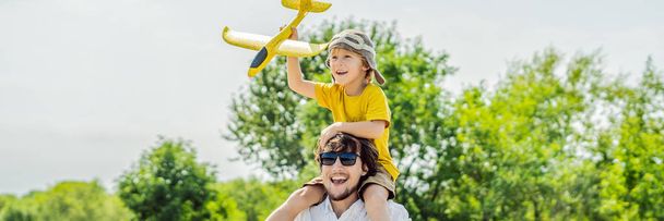 Happy father and son playing with toy airplane against old runway background. Traveling with kids concept. BANNER, LONG FORMAT - Photo, image