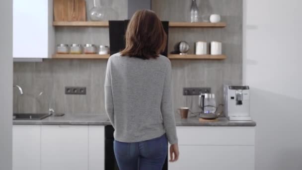 Side view attractive woman near fryer holding kettle and filling hot water in teapot in modern kitchen - Video, Çekim