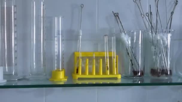 φιαλίδια, ποτήρια και χημική δείγματα στο ράφι στο ιατρικό εργαστήριο - Πλάνα, βίντεο