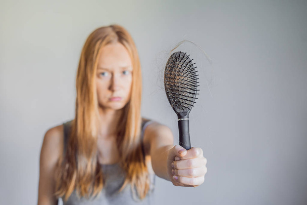 Hair loss in women concept. A lot of lost hair on the comb. - Foto, Imagem