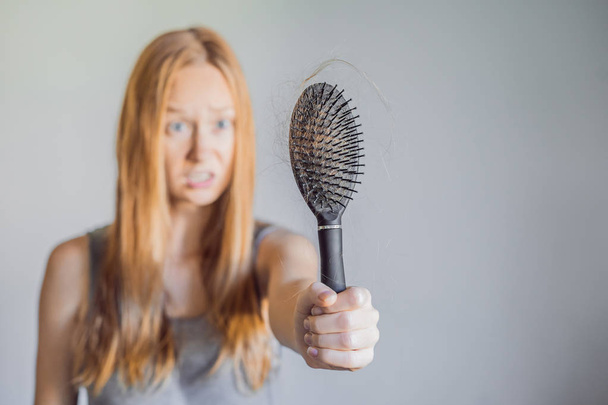 Hair loss in women concept. A lot of lost hair on the comb. - Foto, immagini