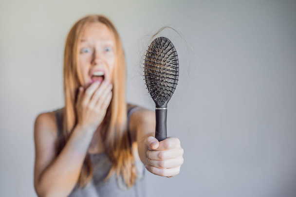 Hair loss in women concept. A lot of lost hair on the comb. - Фото, зображення